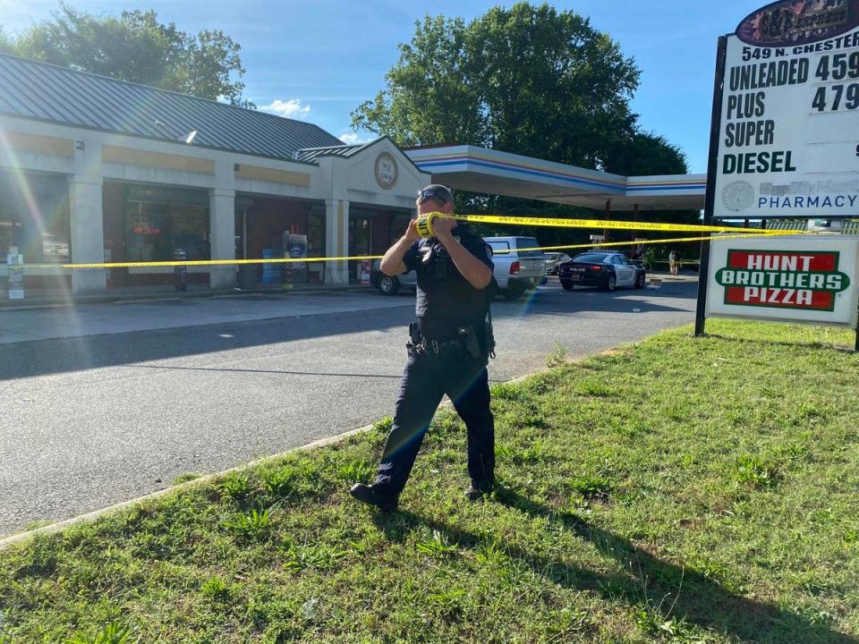 A Gastonia Police officer puts up crime scene tape at the S&K Express on the 500 block of North Chester Street after a 20-year-old Gastonia man was found shot to death there just before 5 p.m. Thursday, June 9, 2022. A 17-year-old Gastonia man faces a first-degree murder charge in the homicide.