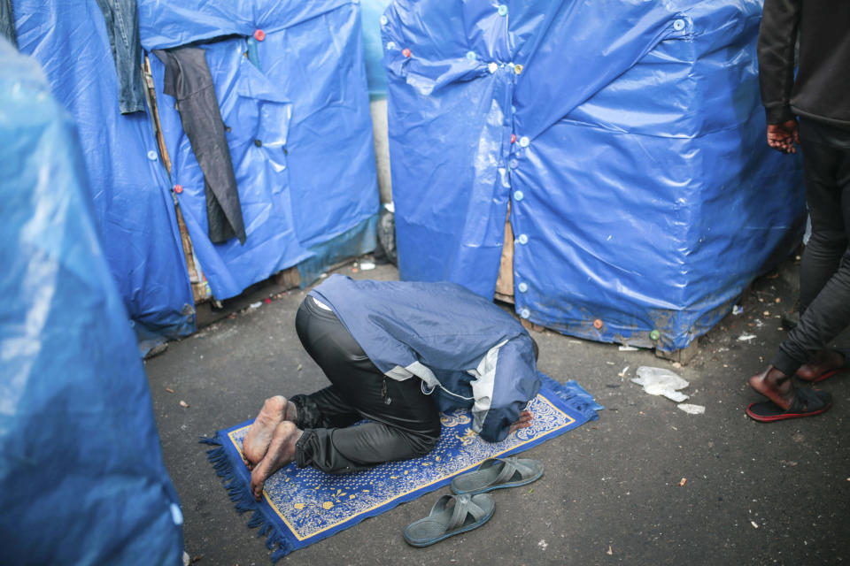A sub-Saharan migrant prays outside the tent he lives in, at Ouled Ziane camp in Casablanca, Morocco, Thursday, Dec. 6, 2018. As Morocco prepares to host the signing of a landmark global migration agreement next week, hundreds of migrants are languishing in a Casablanca camp rife with hunger, misery and unsanitary conditions. These sub-Saharan Africans who dream of going to Europe are a symbol of the problems world dignitaries are trying to address with the U.N.'s first migration compact. (AP Photo/Mosa'ab Elshamy)