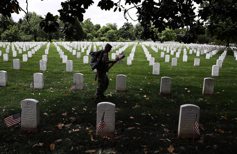 <p>Members of the 3rd U.S. Infantry Regiment place flags at the headstones of U.S. military personnel buried at Arlington National Cemetery, in preparation for Memorial Day May 25, 2017 in Arlington, Virginia. (Photo: Win McNamee/Getty Images) </p>