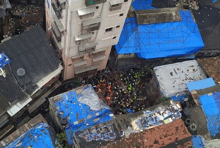 Rescue workers search for survivors at the site of a collapsed building in Mumbai