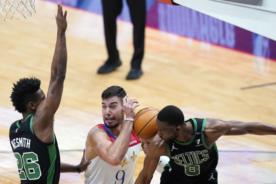 New Orleans Pelicans center Willy Hernangomez (9) battles under the basket between Boston Celtics forward Aaron Nesmith (26) and guard Kemba Walker (8) in the first half of an NBA basketball game in New Orleans, Sunday, Feb. 21, 2021. (AP Photo/Gerald Herbert)