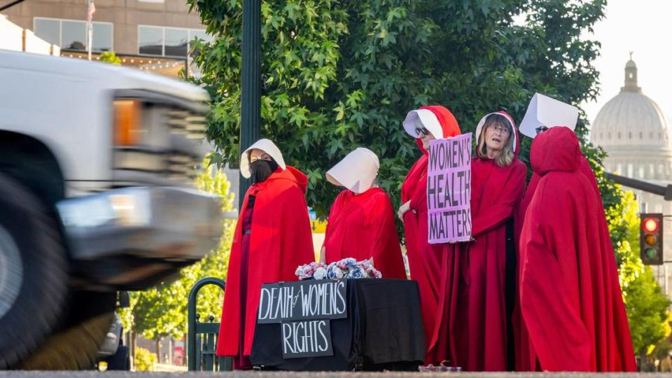 On the two year anniversary of the Dobbs decision by the U.S. Supreme Court, overturning Roe v. Wade, women dressed as characters from Margaret Atwood’s dystopian novel The Handmaid’s Tale, protest the current state of women’s reproductive rights in Idaho.