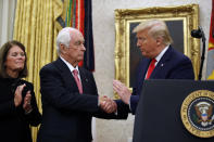 President Donald Trump greets auto racing great Roger Penske during a Presidential Medal of Freedom ceremony in the Oval Office of the White House, Thursday, Oct. 24, 2019, in Washington, as Kathy Penske looks on. (AP Photo/Alex Brandon)