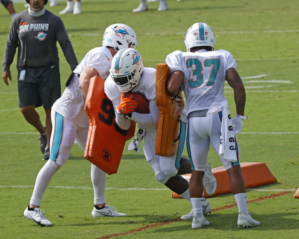 Miami Dolphins running back Patrick Laird (32), left, running back Jordan Howard (34), center, and running back Myles Gaskin (37) run a drill during an NFL football training camp practice in Davie, Fla., Monday, Aug. 17, 2020. (AP Photo/Joel Auerbach)