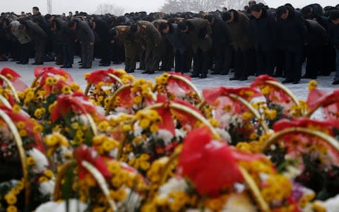 North Koreans pay their respects on the seventh death anniversary of former leader Kim Jong Il - Credit: Dita Alangkara/AP