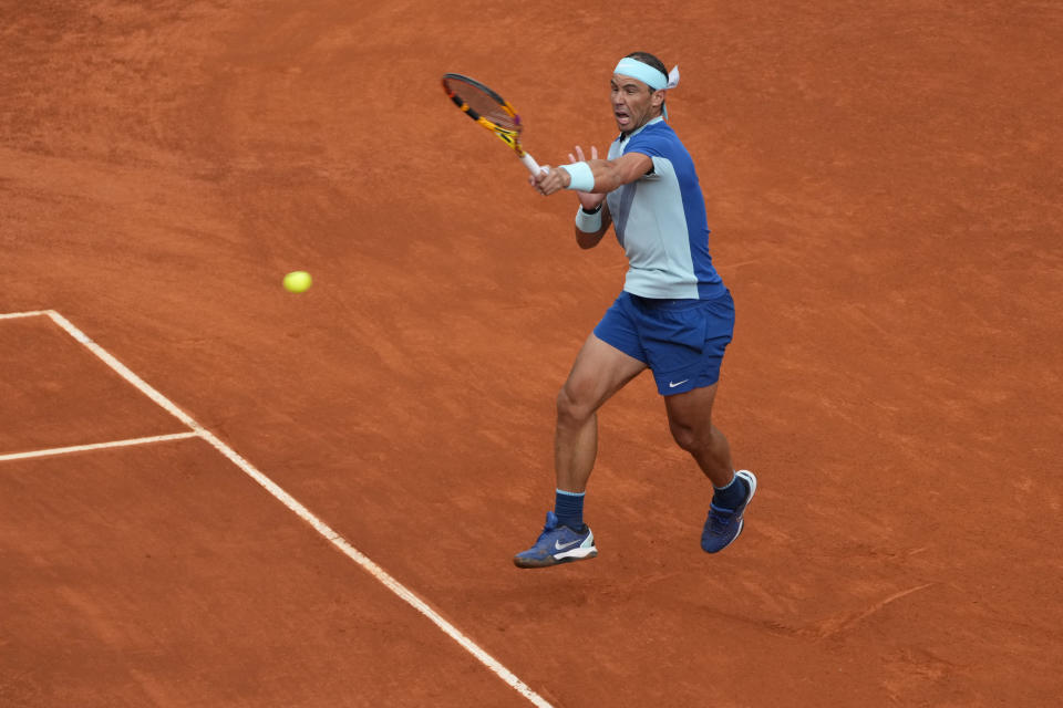 Rafael Nadal of Spain returns the ball to Miomir Kecmanovic of Serbia during their match at the Mutua Madrid Open tennis tournament in Madrid, Spain, Wednesday, May 4, 2022. (AP Photo/Paul White)