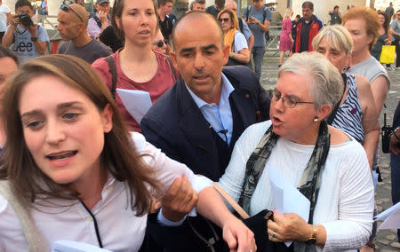 An Italian policeman grabs the arm of Kate McElwee (L), executive director of the Women's Ordination Conference, during a demonstration outside Saint Peter's Square, in Rome, Italy October 3, 2018. Picture taken October 3, 2018. Jamie Manson/Courtesy of National Catholic Reporter/Handout via REUTERS