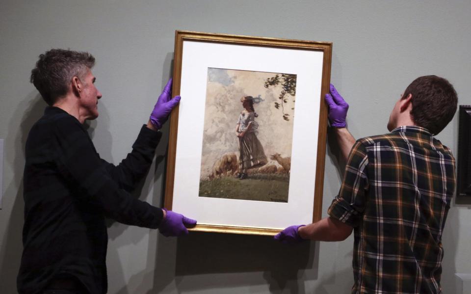 In this Tuesday Feb. 21, 2017 photo, installations technicians Eric Griffin, left, and Gus Boyce hang Fresh Air by Winslow Homer at the Philadelphia Museum of Art in Philadelphia. "American Watercolor in the Age of Homer and Sargent" will be on view from March 1 to May 14, 2017, bringing together masterpieces drawn from public and private collections throughout the county, and will be shown only in Philadelphia. (AP Photo/Jacqueline Larma)