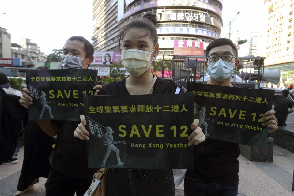 Supporters gather, holding slogan to demand the release of the 12 Hong Kong protesters that have been arrested by mainland Chinese authorities, in Taipei, Taiwan, Sunday, Oct. 25, 2020. A group of 12 people from Hong Kong were allegedly traveling illegally by boat to Taiwan in August when Chinese authorities captured them and detained them.(AP Photo/Chiang Ying-ying)