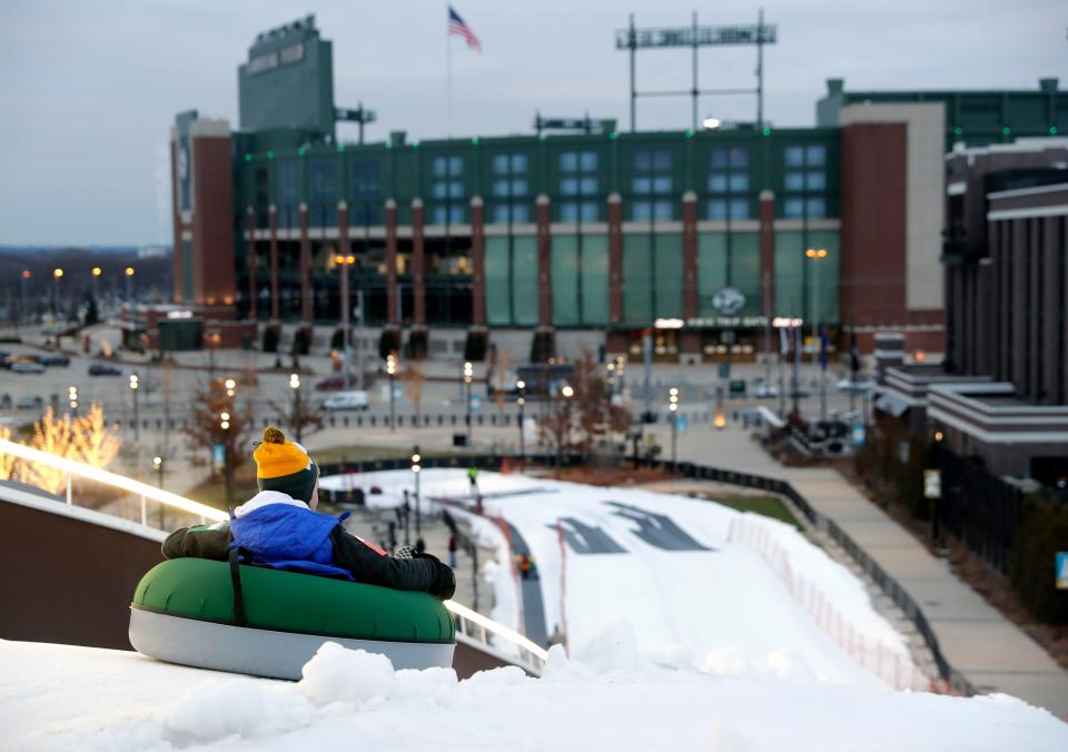 A snow tuber gets a view of Lambeau Field as he begins the ride down Ariens Hill.