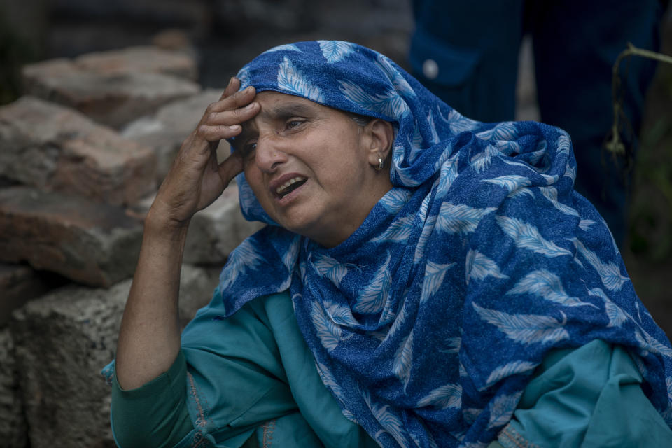 A Kashmiri villager cries beside a house that was destroyed in a gunfight in Pulwama, south of Srinagar, Indian controlled Kashmir, Wednesday, July 14, 2021. Three suspected rebels were killed in a gunfight in Indian-controlled Kashmir on Wednesday, officials said, as violence in the disputed region increased in recent weeks. Two residential houses were also destroyed. (AP Photo/ Dar Yasin)