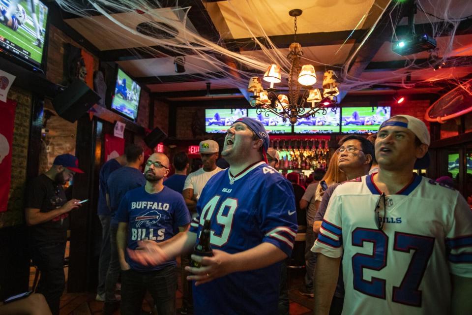 Fans cheer at a Santa Monica bar while watching an NFL game.