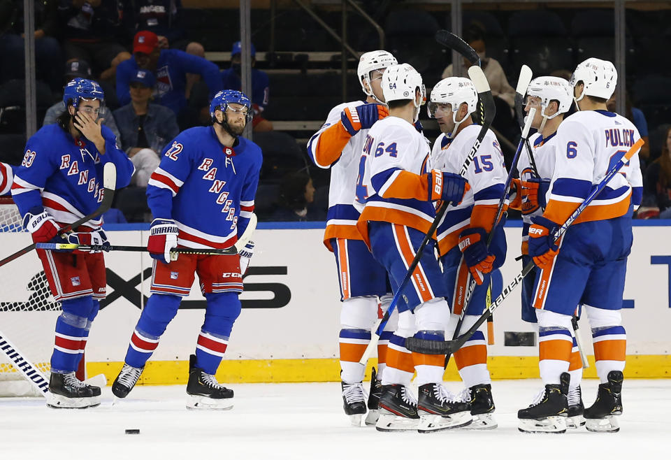 New York Islanders right wing Cal Clutterbuck (15) celebrates with teammates after scoring a goal against the New York Rangers during the second period of a preseason NHL hockey game, Sunday, Sept. 26, 2021, in New York. (AP Photo/Noah K. Murray)