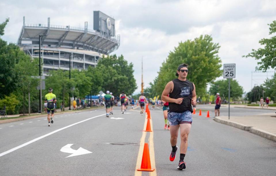 Athletes set out down Curtin Road for the 13.1 mile run in the Ironman 70.3 Pennsylvania Happy Valley on Sunday, June 30, 2024.