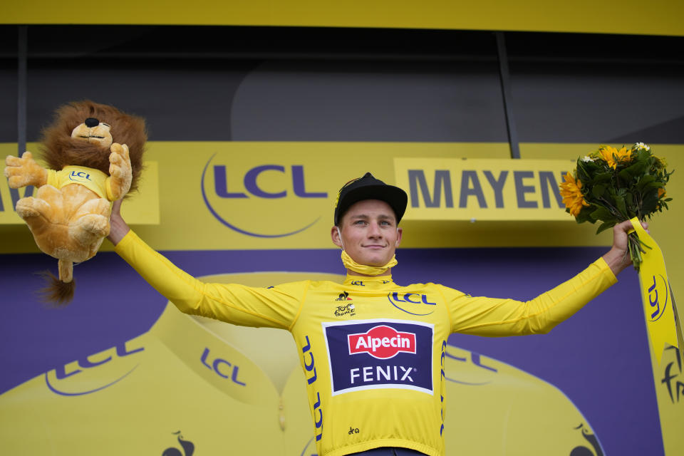 Netherland's Mathieu Van Der Poel wears the overall leader's yellow jersey on the podium of the fifth stage of the Tour de France cycling race, an individual time-trial over 27.2 kilometers (16.9 miles) with start in Change and finish in Laval Espace Mayenne, France, Wednesday, June 30, 2021. (AP Photo/Christophe Ena)