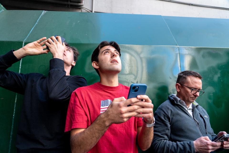 Thomas Taylor (center) watches Maison DesChamps climb the Chase Tower in Phoenix on Feb. 7, 2023.