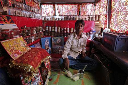 Shamsher Singh, a 19-year-old worker, poses inside a mobile traditional Indian ayurvedic medicine shop in Mumbai March 25, 2014. REUTERS/Danish Siddiqui