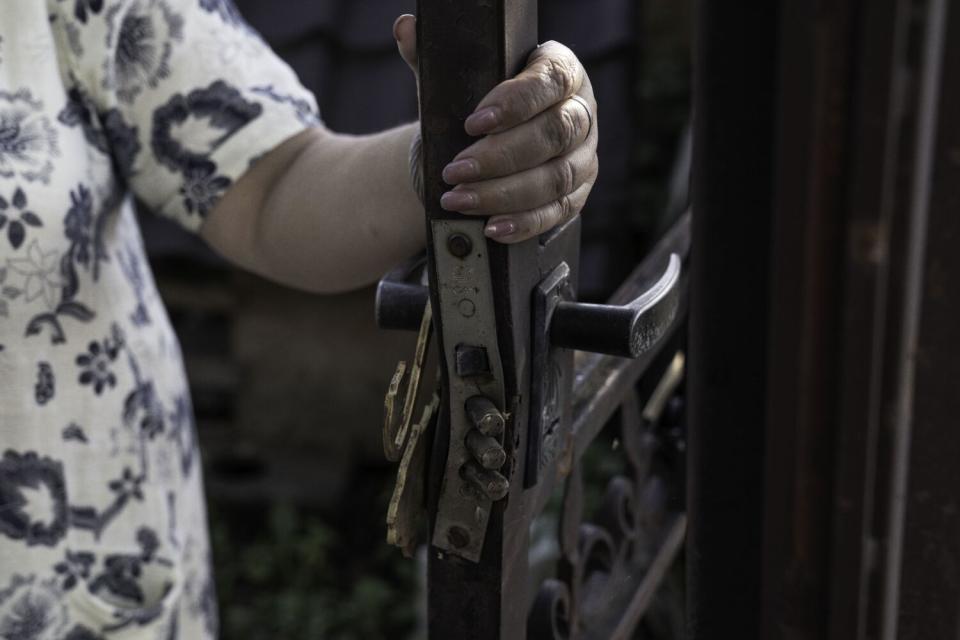 S. holds the door of her home that was kicked in by Russian forces