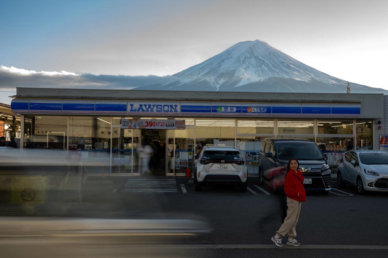 Au Japon, une palissade va être construite devant cette supérette près du Mont Fuji, devenue le repère des touristes (Photo prise devant la fameuse supérette avec vue sur le Mont Fuji, à Fujikawaguchiko le 1er janvier 2024) 