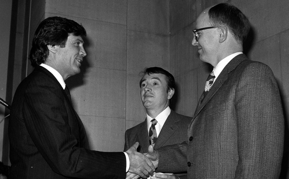 Television arts presenter Melvyn Bragg (left) congratulates artists Gilbert (right) and George after winning the 1986 Turner Prize (PA)