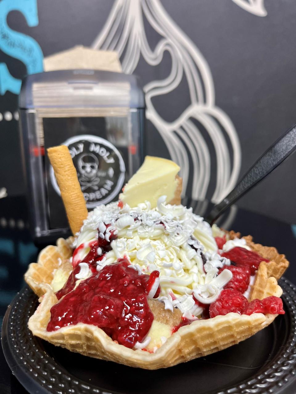 Holy Moly's cheesecake creation has two scoops of white chocolate gelato, whipped cream, raspberry sauce, fresh raspberries, cheesecake pieces, white chocolate flakes and a wafer.