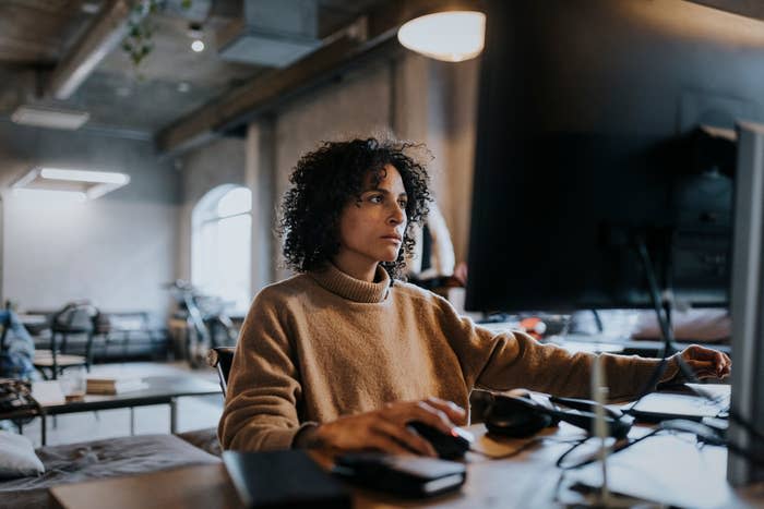 Woman working intently at a computer in an office space