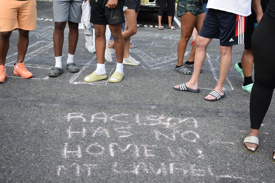 Protester stand near an anti-racism message during a July 2021 demonstration in Mount Laurel.