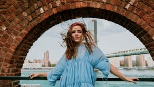 Portrait of young woman standing in windy weather.