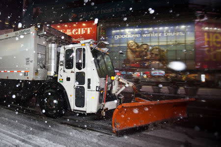 A snow plow makes its way through Times Square in the early morning hours in Manhattan, February 2, 2015. REUTERS/Carlo Allegri