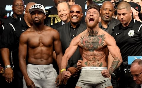 UFC lightweight champion Conor McGregor (R) screams after the face off with Floyd Mayweather Jr. during their official weigh-in at T-Mobile Arena on August 25, 2017 in Las Vegas, Nevada - Credit: Getty Images