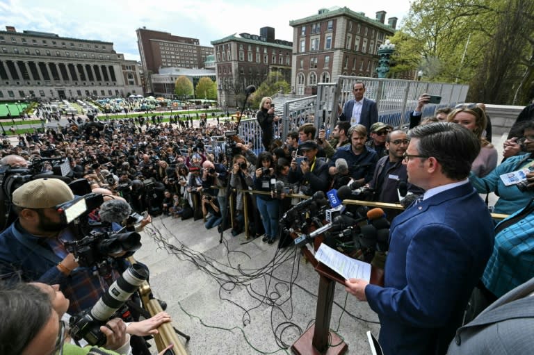 US Speaker of the House Mike Johnson, holding a piece of paper, speaks at Columbia University, with the student pro-Palestinian protest encampment seen in the background (TIMOTHY A. CLARY)