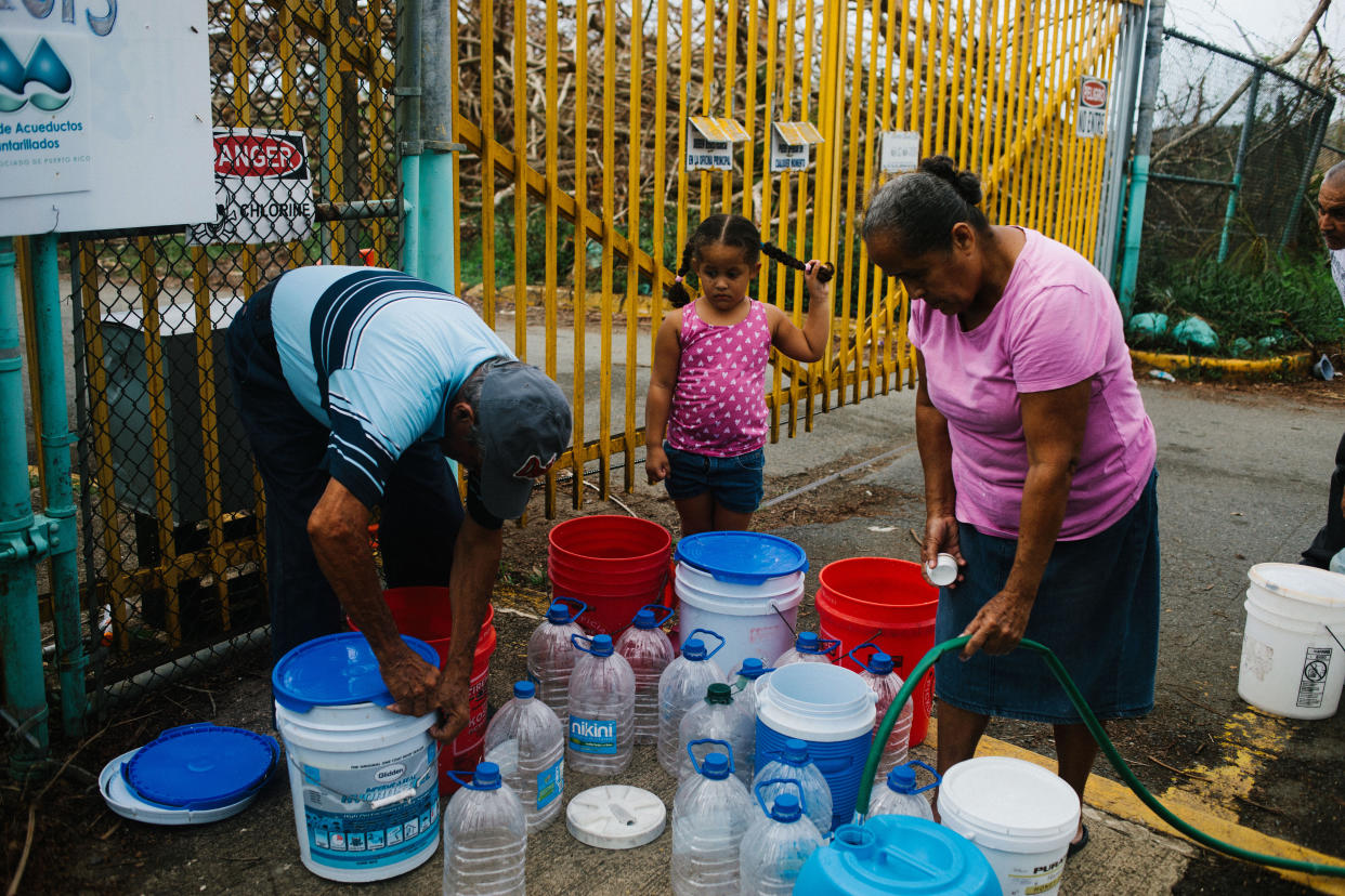 Residents fill containers with water at a center in Rio Grande, Puerto Rico, on Tuesday, Oct. 3, 2017. (Photo: Bloomberg via Getty Images)