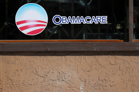 FILE PHOTO: A sign on an insurance store advertises Obamacare in San Ysidro, San Diego, California, U.S., October 26, 2017. REUTERS/Mike Blake