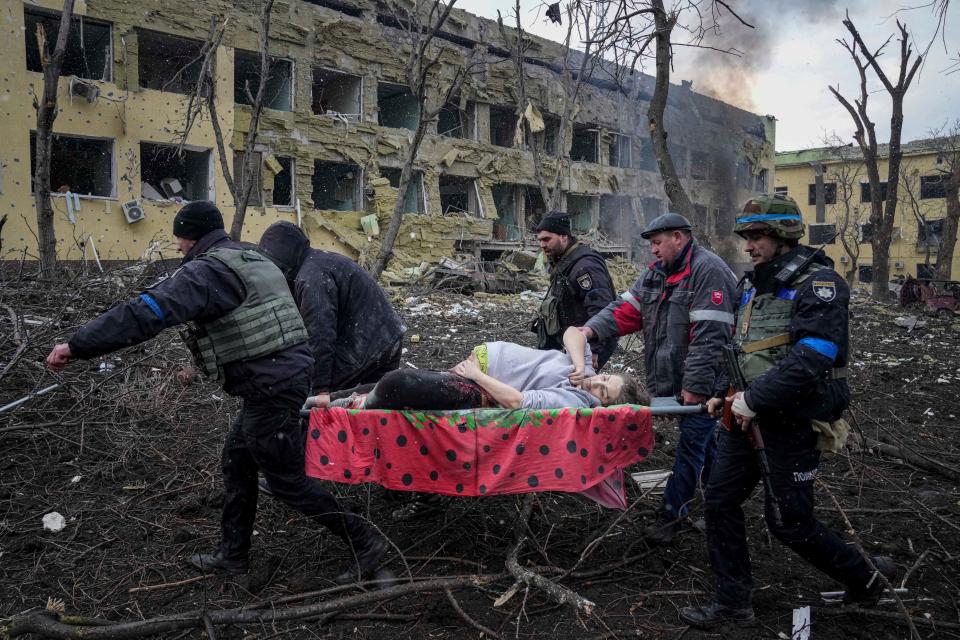 In Mariupol, Ukrainian emergency employees and volunteers carry an injured pregnant woman from a maternity hospital that was severely damaged from a Russian attack on March 9, 2022.