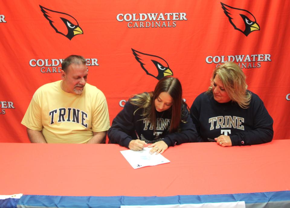 Coldwater's McKenna Hantz signs her letter of intent to compete at Trine University while her parents look on