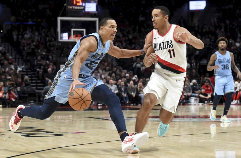 Memphis Grizzlies guard Desmond Bane, left, drives to the basket against Portland Trail Blazers guard Malcolm Brogdon (11) during the second half of an NBA basketball game in Portland, Ore., Sunday, Nov. 5, 2023. (AP Photo/Steve Dykes)