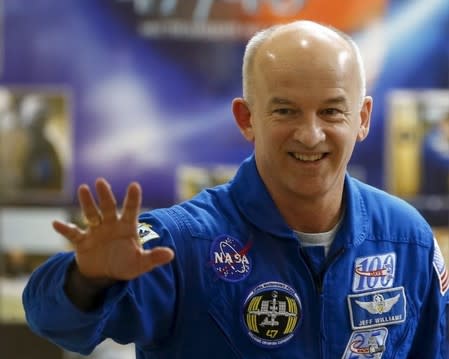 A member of the International Space Station (ISS) crew Jeff Williams of the U.S. waves during a news conference behind a glass wall at the Baikonur cosmodrome, Kazakhstan, March 17, 2016, ahead of the launch scheduled on March 19. REUTERS/Shamil Zhumatov