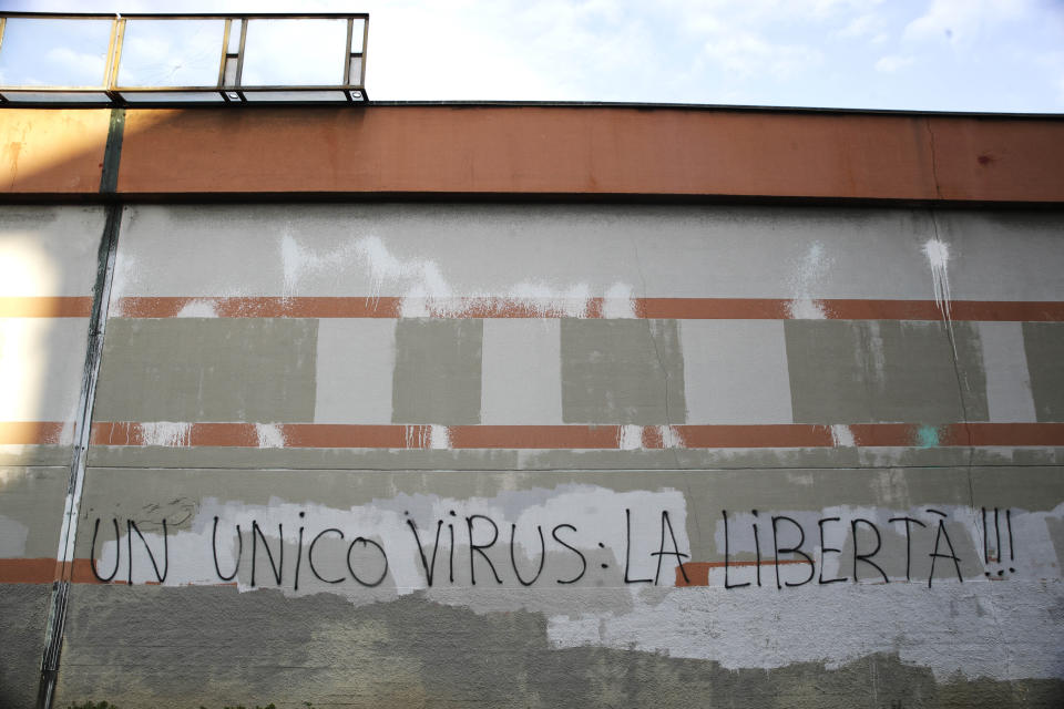 A writing in Italian reading 'There's only one Virus: freedom', is displayed on the wall of San Vittore prison, in Milan, Italy, Sunday, March 15, 2020. (AP Photo/Luca Bruno)