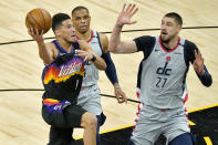 Phoenix Suns guard Devin Booker (1) drives as Washington Wizards center Alex Len (27) defends during the first half of an NBA basketball game, Saturday, April 10, 2021, in Phoenix. (AP Photo/Matt York)