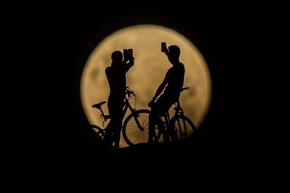 <p>People with bicycles take photos of the Super moon on Jan. 31, 2018 in Lancelin, Australia. (Photo : Paul Kane/Getty Images) </p>