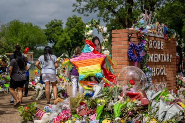 People visit a memorial dedicated to the 19 children and two adults killed during the mass shooting at Robb Elementary School. (Brandon Bell/Getty Images)