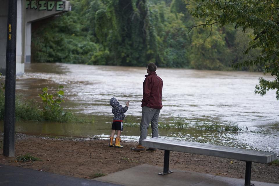 Ian Hauck and his son Paxton Hauck, 3, play near the French Broad River on Friday, September 26. Hurricane Helene is bringing heavy rains to Asheville.