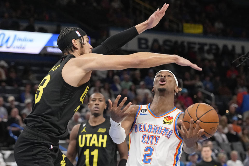 Oklahoma City Thunder guard Shai Gilgeous-Alexander (2) loses control of the ball while defended by Utah Jazz guard Johnny Juzang, left, in the first half of an NBA basketball game Sunday, March 5, 2023, in Oklahoma City. (AP Photo/Sue Ogrocki)