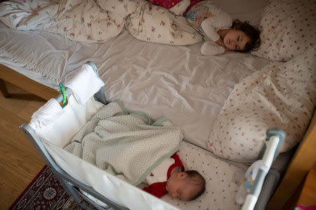 Elena, who is two years and seven-months old and her baby sister, Ioana, who is a few weeks old, take an afternoon nap at their home in London, Britain, February 22, 2019. REUTERS/Alecsandra Dragoi