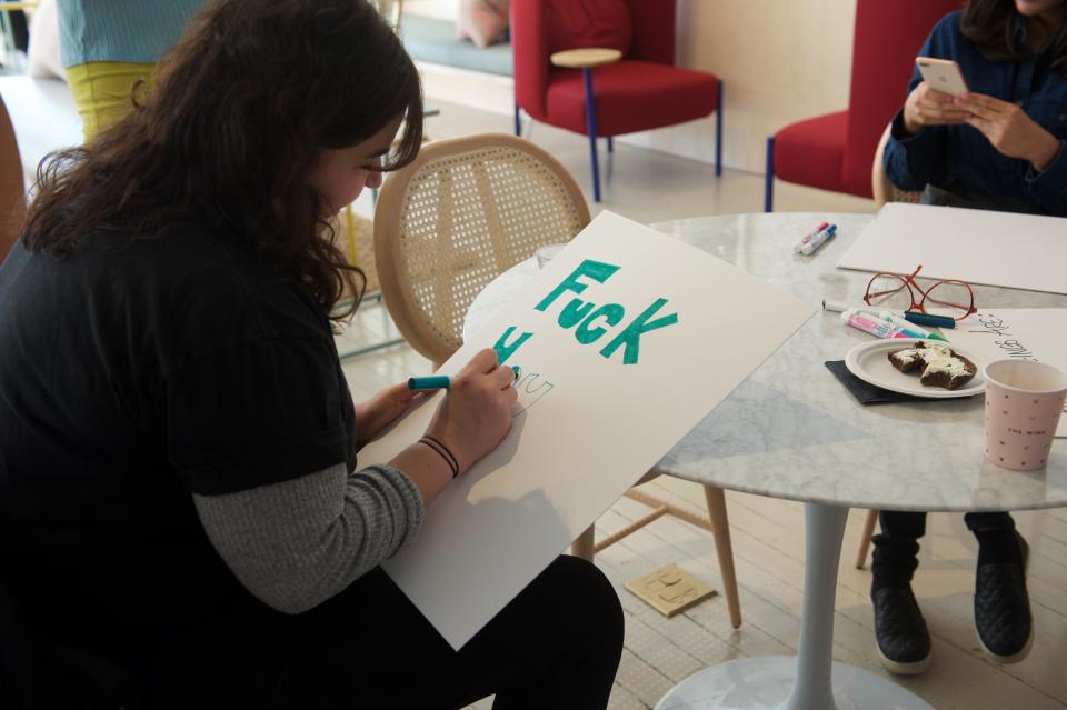 Marchers make signs at women's co-working space and social club, The Wing.