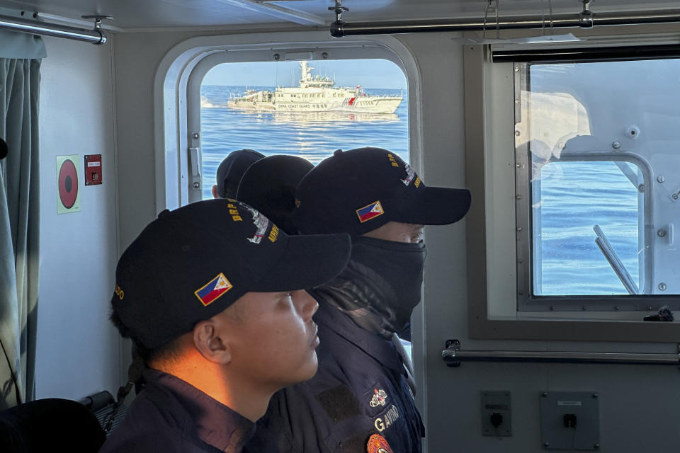 A Chinese coast guard vessel chases the Philippine coast guard vessel BRP Cabra as they approach Second Thomas Shoal, locally known as Ayungin Shoal, during a resupply mission at the disputed South China Sea on Friday Nov. 10, 2023. (AP Photo/Joeal Calupitan)