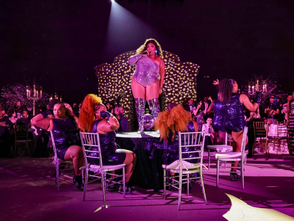 Lizzo performing on a table at the 2023 Met Gala.