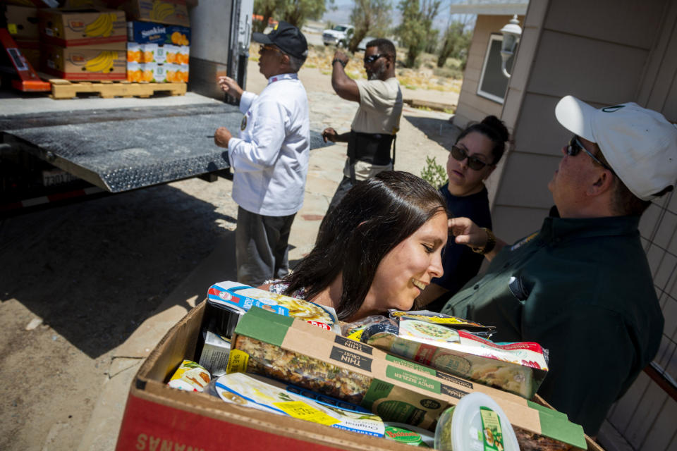 Julia Doss, foreground, helps unload a truck load of food at the Christian Fellowship of Trona, Calif., on Tuesday July 9, 2019. Desert Manna, and Darrin Fikstad, far right, offered a large truck full of food along with several other High Desert charities for the town ravaged by earthquakes and aftershocks. It could be several more days before water service is restored to the tiny town of Trona, where officials trucked in portable toilets and showers. (James Quigg/The Daily Press via AP)
