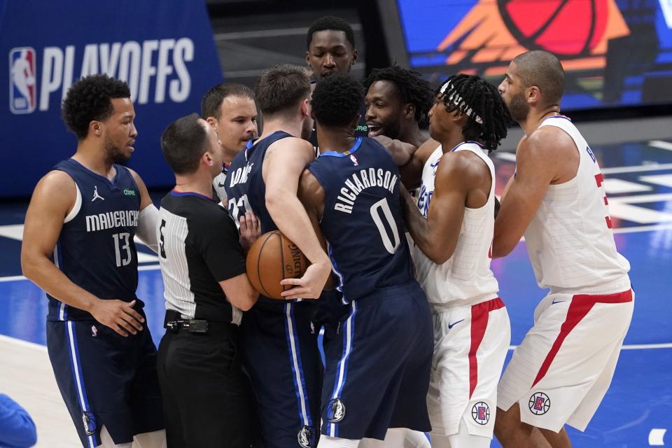 Dallas Mavericks' Luka Doncic, holding ball, and members of the Los Angeles Clippers argue following a play in the first half in Game 3 of an NBA basketball first-round playoff series in Dallas, Friday, May 28, 2021. (AP Photo/Tony Gutierrez)