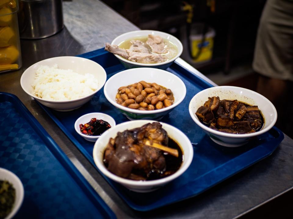 Small bowls of various dishes on a blue tray.